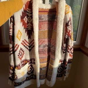 This cozy cardigan with a cool print. Super soft yarn 100% Recycled polyester.